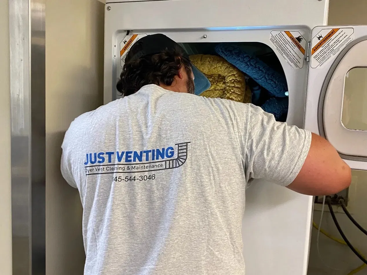 Keith performing a thorough dryer inspection — Just Venting LLC branded shirt visible